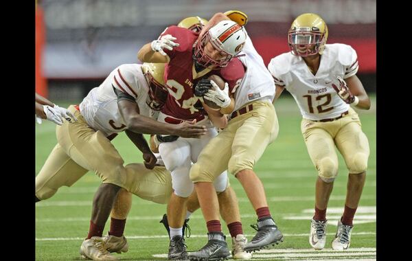 August 22, 2015 Atlanta - Mill Creek's Anthony Presto (24) is brought down by Brookwood's defenders in the second half of their game in the Corky Kell Classic at the Georgia Dome on Saturday, August 22, 2015. Mill Creek won 42 - 7 over the Brookwood. HYOSUB SHIN / HSHIN@AJC.COM