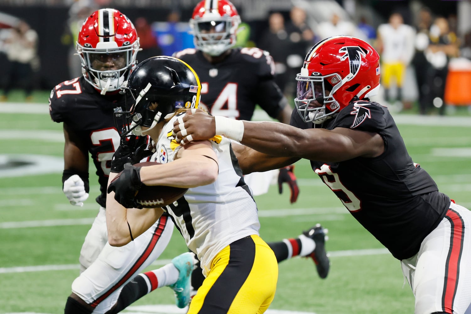 Falcons safety Richie Grant and linebacker Lorenzo Carter (9) tackle Steelers wide receiver Gunner Olszewski during the fourth quarter Sunday at Mercedes-Benz Stadium. (Miguel Martinez / miguel.martinezjimenez@ajc.com)