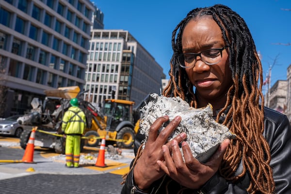 Tears roll down the face of Starlette Thomas, of Bowie, Md., as she holds a chunk of pavement from the Black Lives Matter mural, Monday, March 10, 2025, as the mural begins to be demolished in Washington. "I needed to be here to bear witness," says Thomas, who was present at the 2020 George Floyd protests. "For me the Black Lives Matter sign etched in stone was a declaration of somebodyness and to watch it be undone in this way was very hurtful. To walk away with a piece of that, it means it's not gone. It's more than brick and mortar." (AP Photo/Jacquelyn Martin)