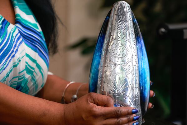 Leslie Miller, Noni Battiste-Kosoko's godmother, holds an urn carrying her cremated remains. (Natrice Miller/natrice.miller@ajc.com)