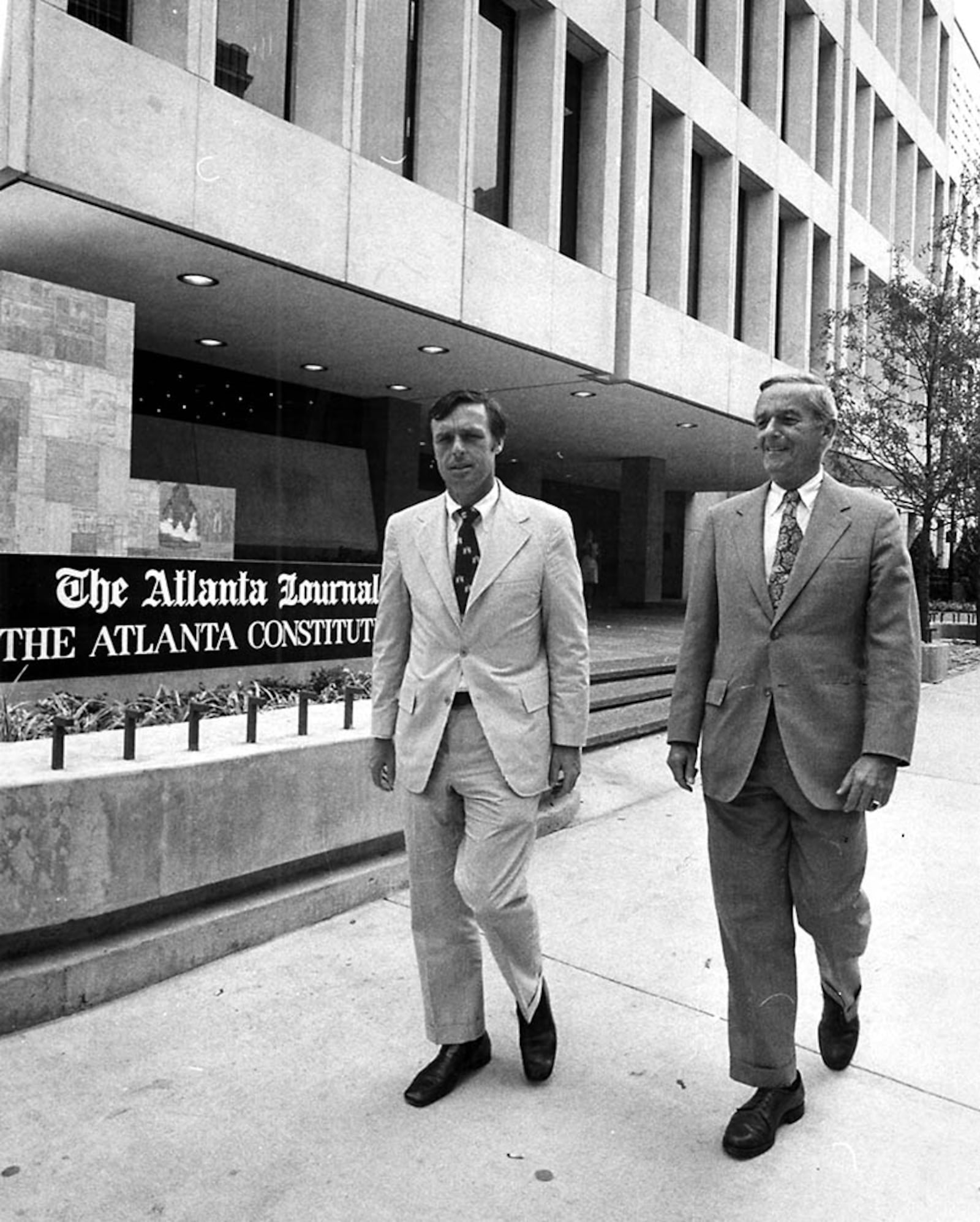 Constitution Editor Reg Murphy, left, walks with Journal Editor Jack Spalding in front of the 72 Marietta Street building. (Dwight Ross, Jr., AJC file)