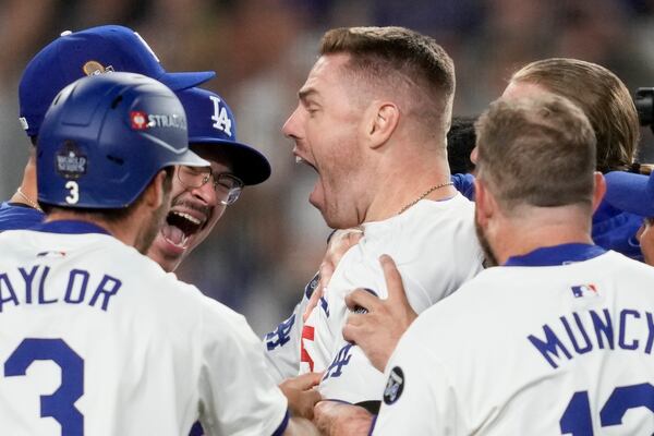 Los Angeles Dodgers' Freddie Freeman celebrates his walk-off grand slam home run against the New York Yankees during the 10th inning in Game 1 of the baseball World Series, Friday, Oct. 25, 2024, in Los Angeles. (AP Photo/Ashley Landis)