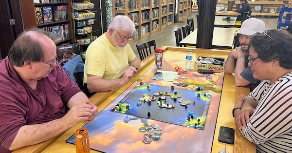 Board gamers play Survive at Meeple Madness, a board game shop in Flowery Branch. The game's goal is to evacuate your pieces from an island that's breaking up.
(Courtesy of Meeple Madness)