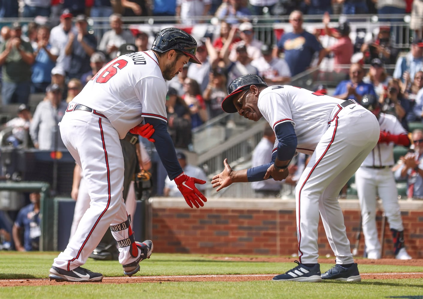 Atlanta Braves' Travis d'Arnaud (16) celebrates his solo home run with third base coach Ron Washington during the second inning of game one of the baseball playoff series between the Braves and the Phillies at Truist Park in Atlanta on Tuesday, October 11, 2022. (Jason Getz / Jason.Getz@ajc.com)