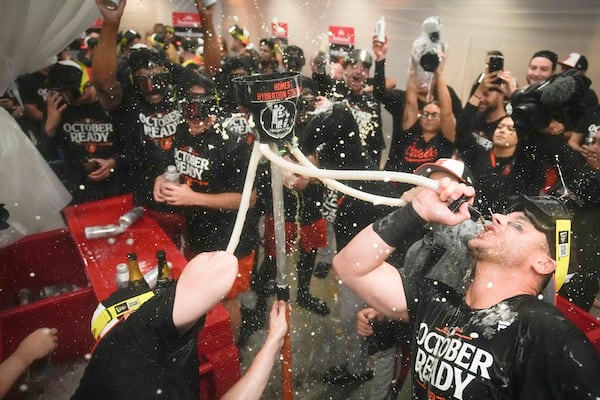 Baltimore Orioles' players celebrate after clinching a playoff birth by defeating the New York Yankees in baseball game, Tuesday, Sept. 24, 2024, in New York. (AP Photo/Bryan Woolston)