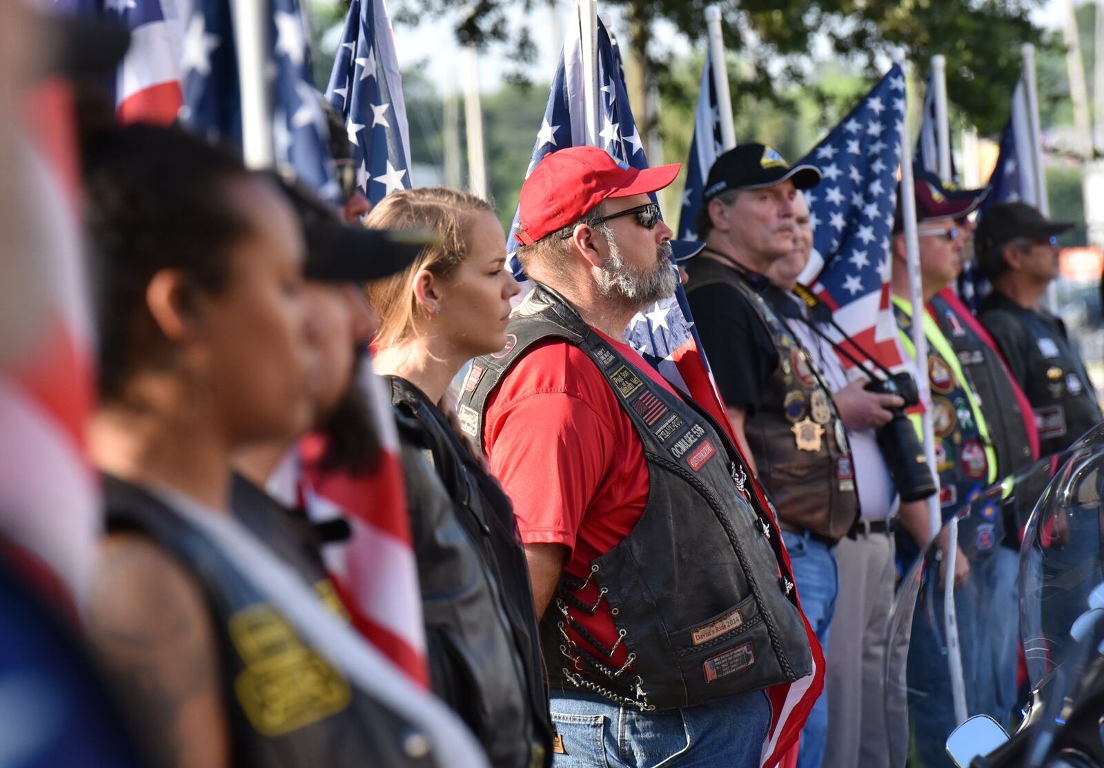 Volunteers, including Don “Big Don” Wilson (center), line up with American flags before the funeral service for Savannah police officer Kelvin Ansari, who was killed on duty. Wilson is Georgia’s state captain of the Patriot Guard Riders. HYOSUB SHIN / HSHIN@AJC.COM