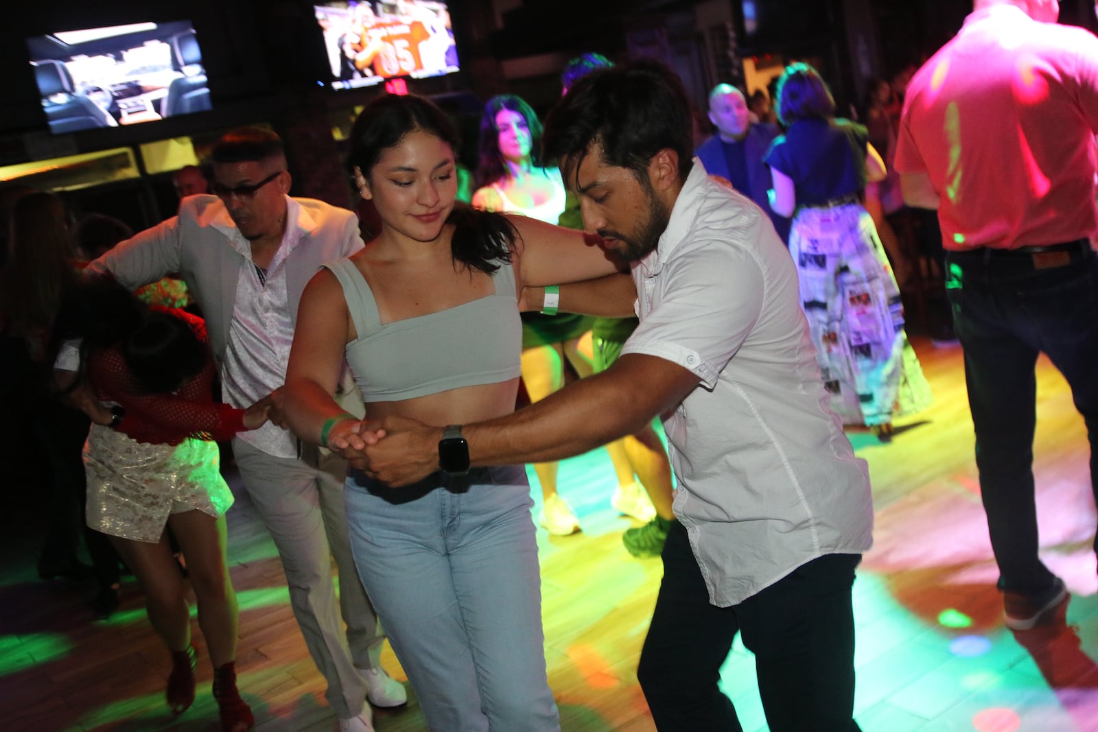 Dancers concentrate on their salsa moves at a Dance4Fun ATL class at Tony's Sports Grill in Johns Creek.