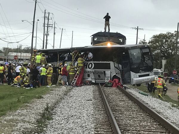 Biloxi firefighters assist injured passengers after their charter bus collided with a train in Biloxi, Miss. on Tuesday. At least three people died and 35 were injured, officials said. The bus was traveling from the Austin area and was carrying members of a senior center in Bastrop. (John Fitzhugh/Sun Herald)