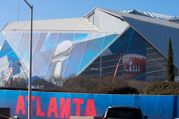 Workers continue to wrap parts of Mercedes-Benz Stadium with Super Bowl LIII advertisement material in Atlanta.