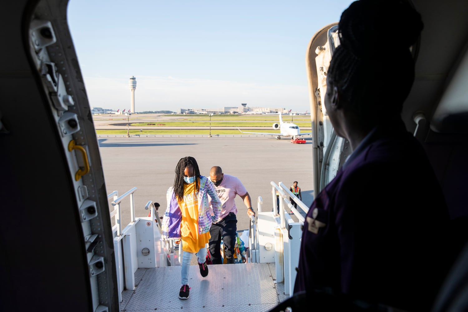 Inami Samuels, 7, and her father Titus Samuels board a plane as part of Delta’s Dream Flight 2022 at Hartsfield-Jackson Atlanta International Airport on Friday, July 15, 2022. Around 150 students ranging from 13 to 18 years old will fly from Atlanta to the Duluth Air National Guard Base in Duluth, Minnesota. (Chris Day/Christopher.Day@ajc.com)