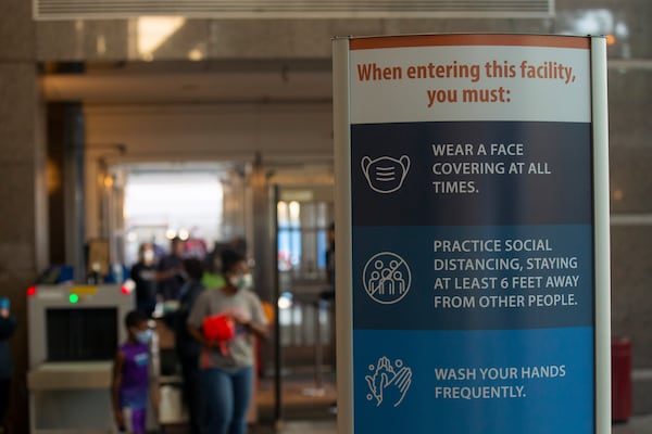 In this file photo at The Fulton County Government Center all visitors and employees entering the Fulton County Government Center are told to wear a mask, practice social distancing. They also had their temperatures checked. (Rebecca Wright for The Atlanta Journal-Constitution)