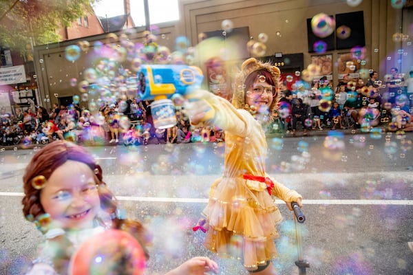 Hannah Post (aka Dorothy, left) and Charlotte Ward (the Cowardly Lion) make bubbles during last year's Dragon Con Parade.