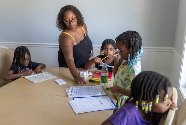 Ebon Sledge (center) helps some of her children with their homework PHIL SKINNER FOR THE ATLANTA JOURNAL-CONSTITUTION