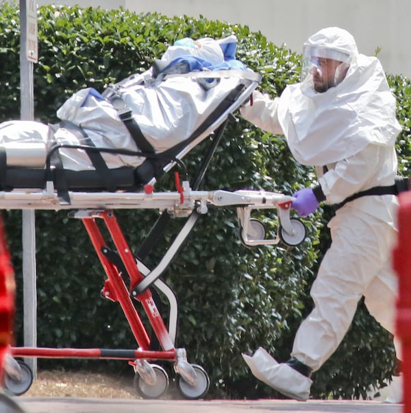 In this file photo, medical workers roll patient Nancy Writebol into Emory University Hospital. The second American aid worker infected with Ebola arrived Aug. 5, 2014, in Atlanta. Writebol arrived in a chartered jet at Dobbins Air Reserve Base and was then taken in an ambulance to Emory University Hospital. She was rolled into the hospital by suited medical personnel. Three days earlier, Dr. Kent Brantly, also diagnosed with the virus, arrived at Emory University Hospital and walked from the ambulance. Both recovered. JOHN SPINK / JSPINK@AJC.COM