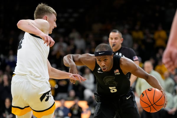 Michigan State guard Tre Holloman (5) drives past Iowa guard Josh Dix, left, during the first half of an NCAA college basketball game, Thursday, March 6, 2025, in Iowa City, Iowa. (AP Photo/Charlie Neibergall)