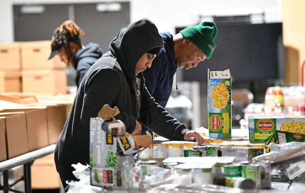 Volunteers including Jennifer Garcia (center) prepare meal kits for the big Saturday give away at Hosea Helps, Friday, November 22, 2024, in Atlanta. “Thanksgiving” at Hosea Helps will begin on Saturday when they distribute 500 meal kits to families consisting of a turkey, with all the sides and beverages. Elisabeth Omilami, president of Hosea Helps, said allowing families to go home and cook their meals will give them a sense of dignity. (Hyosub Shin / AJC)