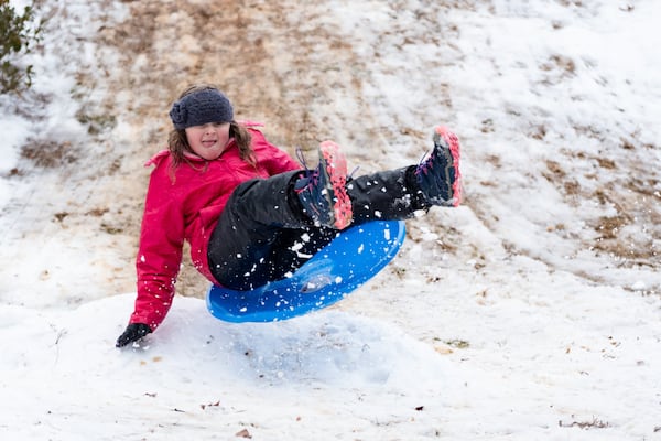 Dylan Barrow, 8, catches some air while sledding with her family in the Lindmoor Woods neighborhood of Decatur on Friday, Jan. 10, 2025. (Ben Gray for the AJC)