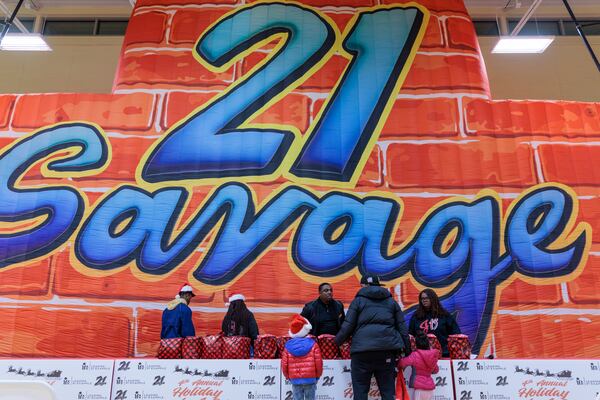 People receive gifts at the Wade Walker Park Family YMCA in Stone Mountain on Wednesday, December 21, 2022 . The event was put on by rapper 21 Savage’s Leading By Example foundation. (Arvin Temkar / arvin.temkar@ajc.com)