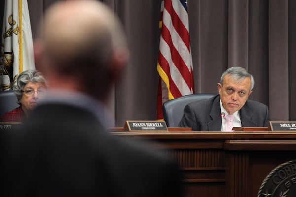 Mike Boyce, chairman of the Cobb County Commission, listens to a speaker in Marietta.