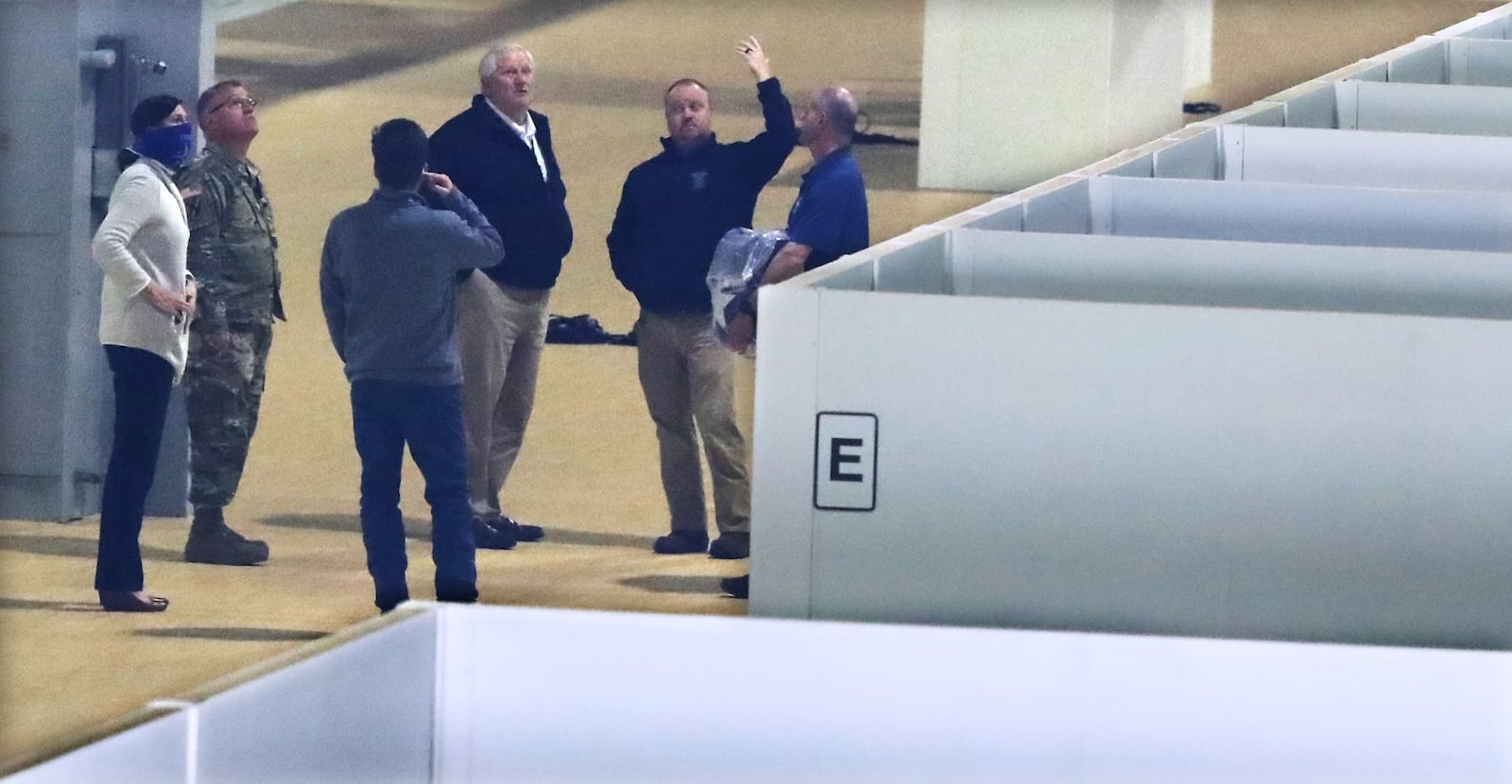 Officials look over a portion of the 200-bed temporary hospital being built inside part of the Georgia World Congress Center for coronavirus patients on Wednesday, April 15, 2020. The pop-up hospital is being constructed by the Georgia National Guard, Georgia Emergency Management and Homeland Security Agency, Department of Community Health, Department of Public Health, and independent contractors. (Curtis Compton / ccompton@ajc.com)