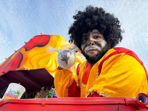 Krewe of Zulu member Jeremy Speed, 40, holds a hand-painted coconuts he plans to throw into the crowd as he ride atop a float for a Mardi Gras Day parade on Tuesday, March 4, 2025 in New Orleans. (AP Photo/Jack Brook)