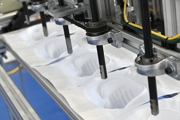 Tomas Nedbal (not pictured) demonstrates a cutting station that is part of an N95 mask production line being developed at ThermoPore Materials Corporation, a plastics manufacturer in Newnan. ThermoPore received government approval to make a new type of N95 that utilizes a different filtration material. (Hyosub Shin / Hyosub.Shin@ajc.com)