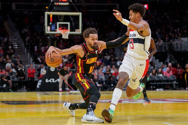 Atlanta Hawks guard Trae Young, left, dribbles while guarded by Washington Wizards guard Jordan Poole, right, during the first half of an Emirates NBA Cup basketball game, Friday, Nov. 15, 2024, in Atlanta. (AP Photo/Jason Allen)