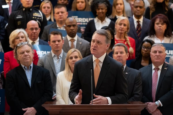 U.S. Sen. David Perdue of Georgia, flanked by supporters, speaks to the media after qualifying to run for a second term on March 2. BenGray.com/Special