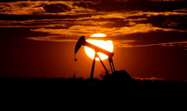 The sun sets behind an idle pump jack near Karnes City, Texas, Wednesday, April 8, 2020. Demand for oil continues to fall due to the new coronavirus outbreak. (AP Photo/Eric Gay)