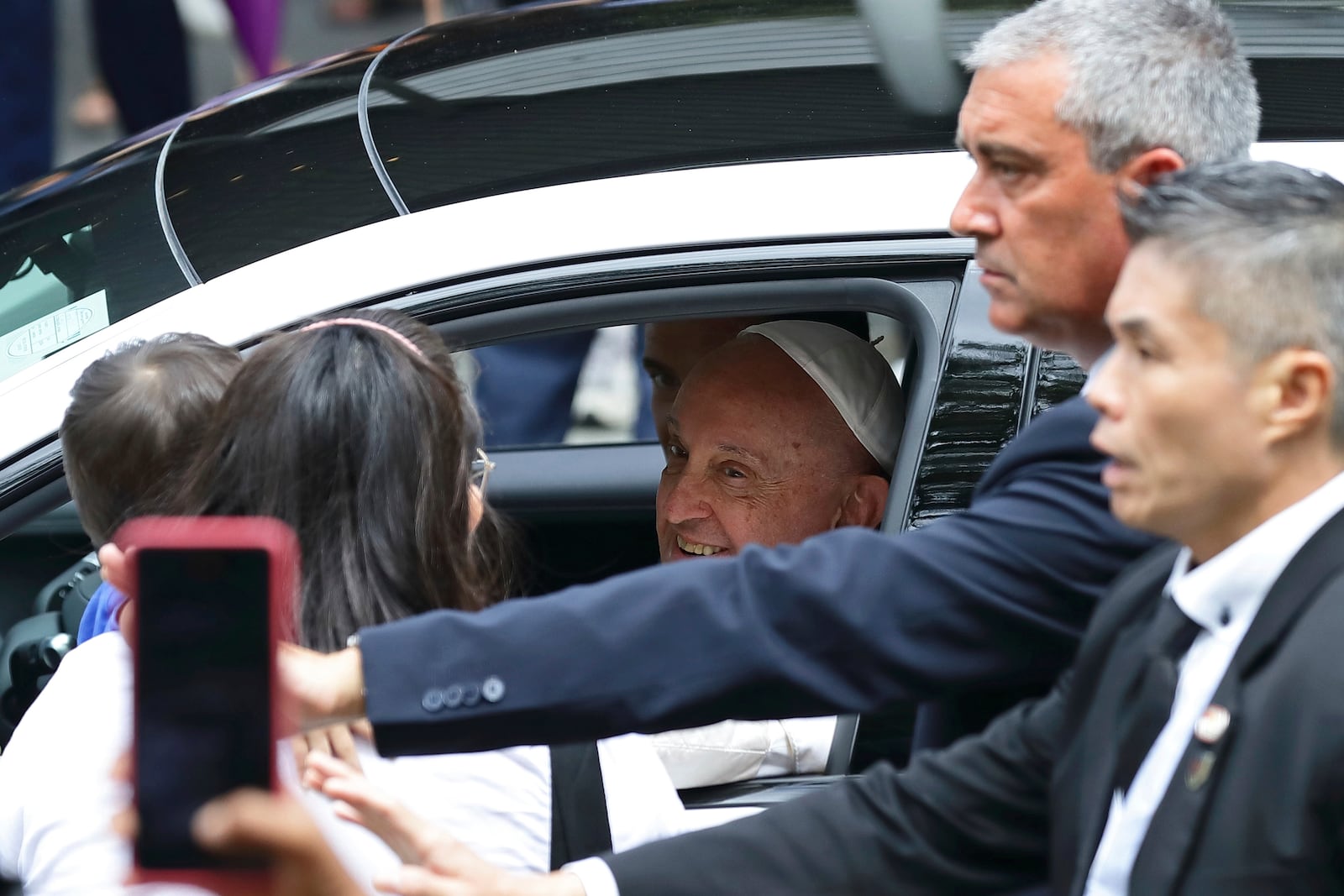 Pope Francis blesses a child as he departs National University of Singapore after delivering the state address in Singapore, Thursday, Sept. 12, 2024.(AP Photo/Suhaimi Abdullah)