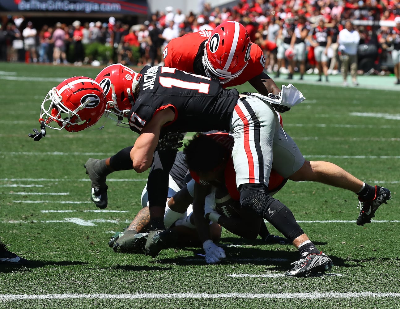 Georgia defensive back Dan Jackson levels wide receiver Dominic Lovett, separating him from his helmet, during the G-Day game on Saturday, April 13, 2024 in Athens.  Curtis Compton for the Atlanta Journal Constitution