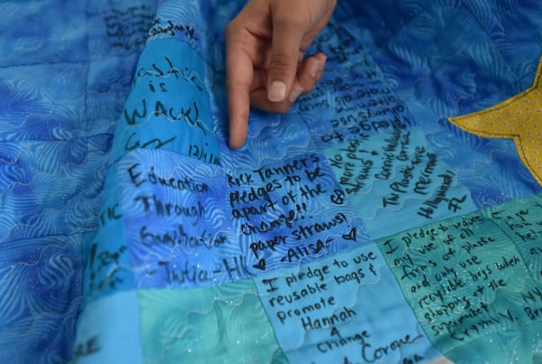 Hannah Testa, at her home in Cumming, shows off a quilt decorated with pledges of support to protect the environment and reduce plastic pollution. Testa, 16, has been an environmental activist since the age of 10. In 2017, she partnered with state Sen. Michael Williams to proclaim Feb. 15 as Plastic Pollution Awareness Day. HYOSUB SHIN / HSHIN@AJC.COM