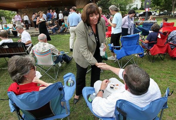 Martha Zoller, candidate for the 9th congressional seat, shakes hands with Terry Dawson with his wife Marie Dawson looking on while working the crowd for votes at the Dahlonega-Lumpkin Chamber After Hours event on Tuesday, Aug. 7, 2012.