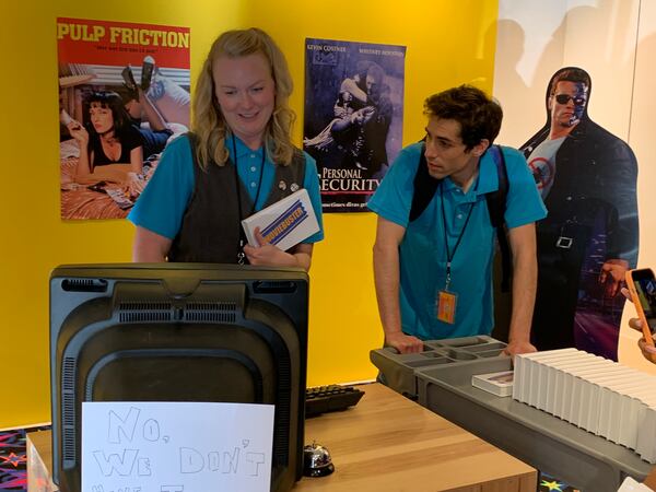 The "Save the Video Store" interactive at The Avenue West Cobb is a faux video rental store from the 1990s. Actors Erin Stegeman (left, who created the experience) and Zach Canner play employees. RODNEY HO/rho@ajc.com