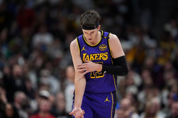 Los Angeles Lakers guard Austin Reaves gestures after hitting a 3-point basket against the Denver Nuggets in the second half of an NBA basketball game, Saturday, Feb. 22, 2025, in Denver. (AP Photo/David Zalubowski)