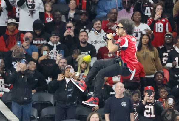 Ludacris descends from the top of the stadium while performing during the game.  The Atlanta Falcons celebrate Hip-Hop 50 with performances and appearances during their NFL football game between the Atlanta Falcons and the New Orleans Saints in Atlanta on Sunday, Nov. 26, 2023.   (Bob Andres for the Atlanta Journal Constitution)