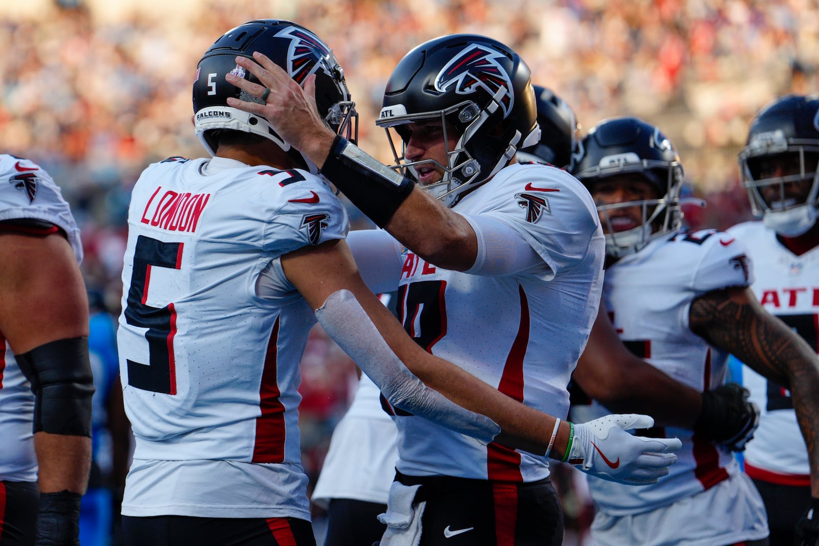 Atlanta Falcons wide receiver Drake London (5) celebrates a touchdown with quarterback Kirk Cousins (18) in the first half of an NFL football game against the Carolina Panthers in Charlotte, N.C., Sunday, Oct. 13, 2024. (AP Photo/Jacob Kupferman)