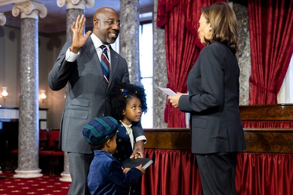 U.S. Sen. Raphael Warnock (D-GA) holds up in his hand during a ceremonial swearing in with Vice President Kamala Harris at the Capitol in Washington, DC on Jan. 3, 2022. (Nathan Posner for the Atlanta Journal-Constitution)