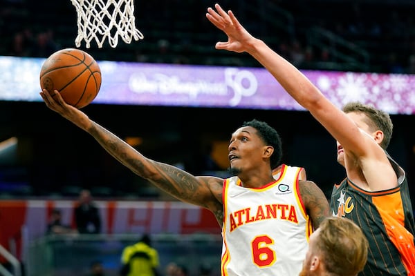 Atlanta Hawks guard Lou Williams (6) gets past Orlando Magic center Moritz Wagner, right, for a shot during the first half of an NBA basketball game, Wednesday, Dec. 15, 2021, in Orlando, Fla. (AP Photo/John Raoux)