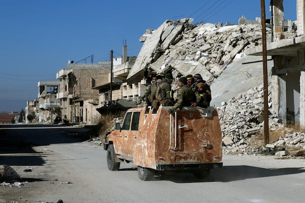 Syrian opposition fighter ride on a truck in Khan Sheikhoun, southwest of Aleppo, Sunday, Dec. 1, 2024. Syrian opposition insurgency launched a campaign on Wednesday with a two-pronged attack on Aleppo and the countryside around Idlib.(AP Photo/Ghaith Alsayed)