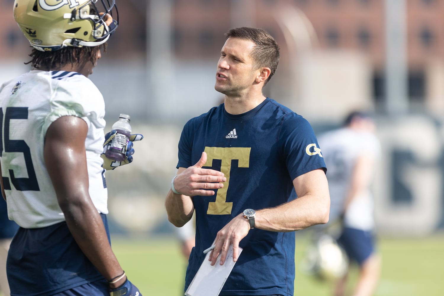 Defensive coordinator Andrew Thacker talks with Charlie Thomas (25) during the first day of spring practice for Georgia Tech football at Alexander Rose Bowl Field in Atlanta, GA., on Thursday, February 24, 2022. (Photo Jenn Finch)