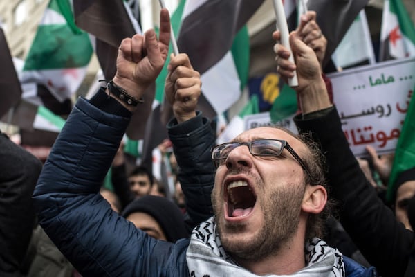 ISTANBUL, TURKEY - FEBRUARY 22:  People hold signs and chant slogans during a protest against the Russian and Syrian forces bombing and blockade of the Syrian enclave of Eastern Ghouta, outside the Russian Consulate on February, 22, 2018 in Istanbul, Turkey. Syrian forces supported by Russian warplanes have continued to bomb the suburb over the past three days bring the civilian death toll to more than 270. Since early February the UN has recorded 346 civilian deaths and 878 wounded mostly from airstrikes. Russia has denied any involvement in the airstrikes.  (Photo by Chris McGrath/Getty Images)