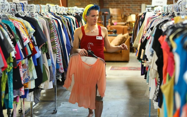 On a recent Thursday afternoon in October, Ryan Peterson organized clothing items for sale at the Lost-n-Found Thrift and Consignment shop in Atlanta where he works. Peterson came through the Lost-N-Found youth program. The thrift store is the main way the youth program is funded. (Curtis Compton / ccompton@ajc.com)