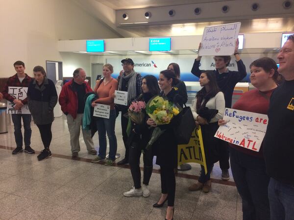 Well wishers gather to welcome a refugee family from Afghanistan at Hartsfield Jackson-International Airport on Monday night. Photo: Ellen Eldridge