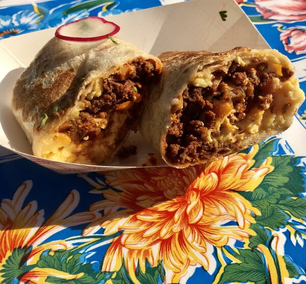 Breakfast burritos are generously filled, tightly rolled and spend quality time on the griddle. Among fillings, the chorizo y papas (pictured) — spicy pork chorizo, moist, fluffy scrambled eggs and potato — is satisfying. LIGAYA FIGUERAS / LFIGUERAS@AJC.COM