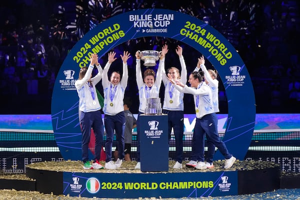 Italy's tennis team celebrates on the podium after winning the Billie Jean King Cup final against Slovakia at the Martin Carpena Sports Hall in Malaga, southern Spain, on Wednesday, Nov. 20, 2024. (AP Photo/Manu Fernandez)