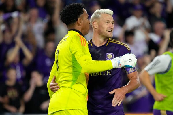 Orlando City goalkeeper Pedro Gallese, left, and defender Robin Jansson celebrate after defeating Atlanta United in an MLS Semifinal Conference playoff soccer match, Sunday, Nov. 24, 2024, in Orlando, Fla. (AP Photo/John Raoux)