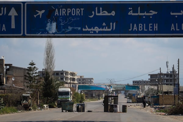 An abandoned makeshift checkpoint is seen in the middle of an empty street following the recent wave of violence between Syrian security forces and gunmen loyal to former President Bashar Assad, as well as subsequent sectarian attacks, on the outskirts of Lattakia, Syria's coastal region, Monday, March 10, 2025. (AP Photo/Omar Albam)