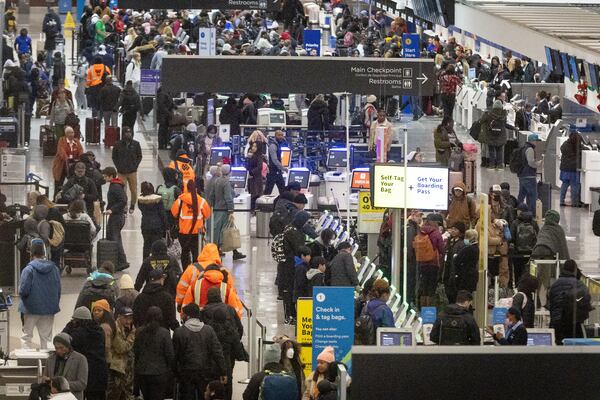 Early morning travelers check in before their flights at Hartsfield-Jackson International Airport Saturday, Dec. 24, 2022. (Photo: Steve Schaefer / steve.schaefer@ajc.com)