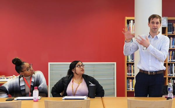 Sam Rauschenberg (right), vice president of data strategy at Achieve Atlanta, speaks during a training session for Atlanta Public Schools counselors on how to use a new computer-based college search tool, while Chynna Moore (middle), a volunteer at Atlanta Public Schools, and another attendee listen on Monday, Jan. 27, 2020, at Maynard Jackson High School in Atlanta. (Christina Matacotta/crmatacotta@gmail.com)